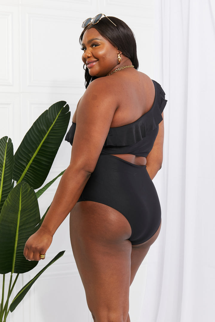 a woman in a black one piece swimsuit