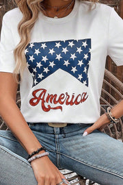 a woman sitting on a chair wearing an american t - shirt