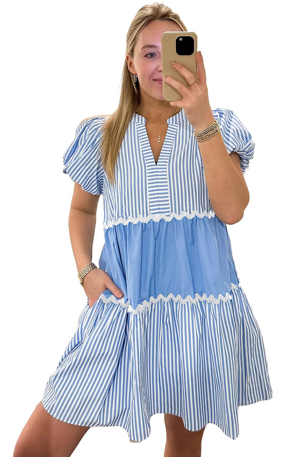 a woman taking a picture of herself in a blue and white dress