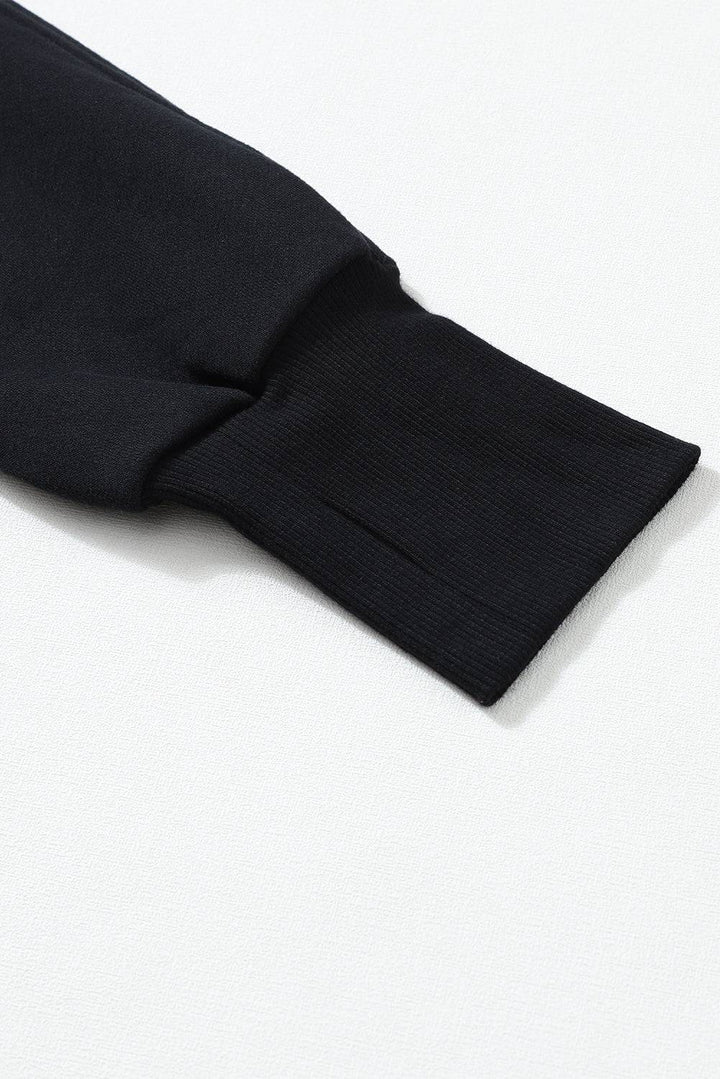 a close up of a black shirt on a white surface