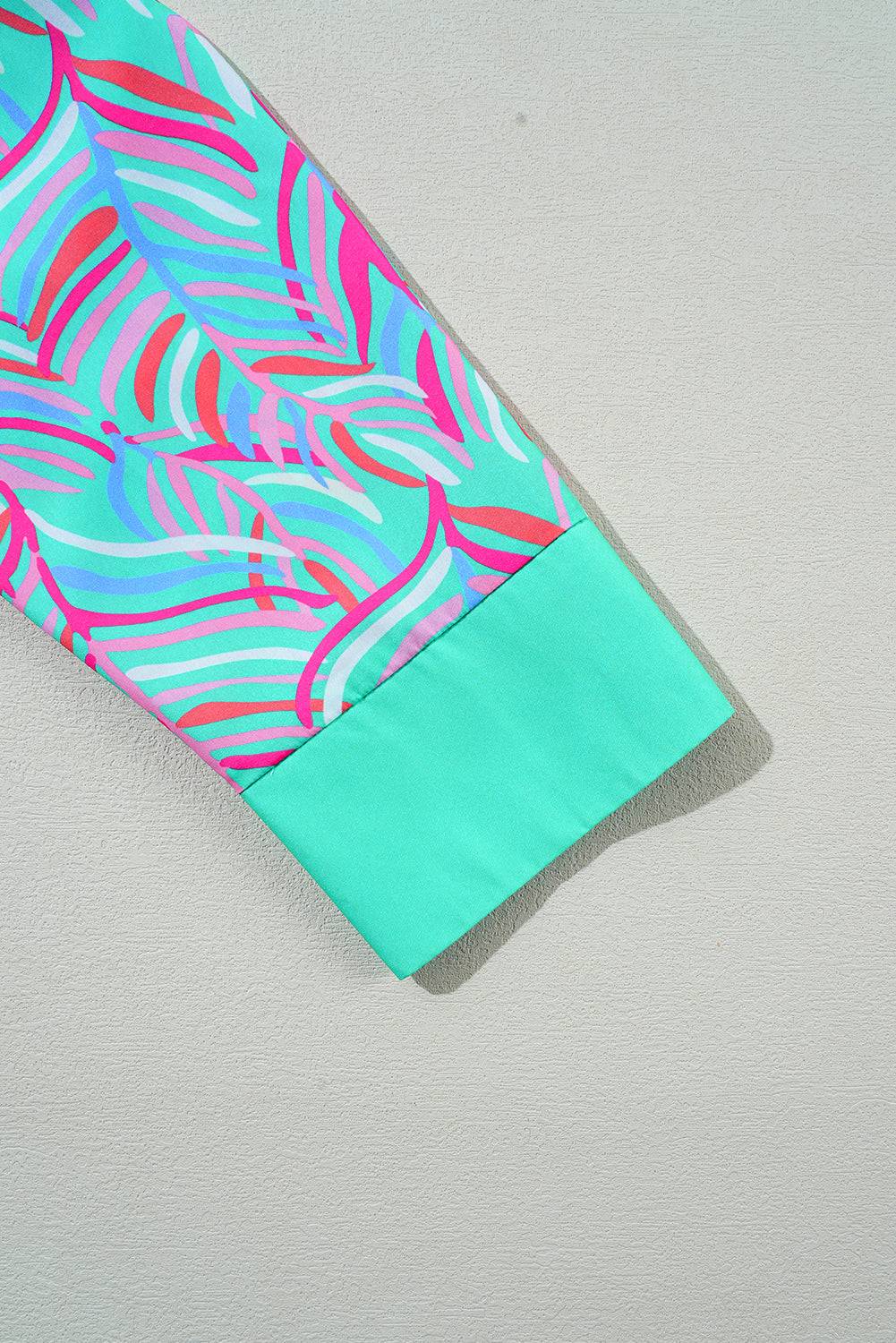 a blue and pink tie laying on top of a white surface