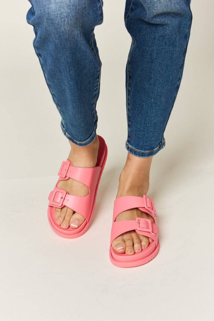 a person wearing pink sandals and jeans