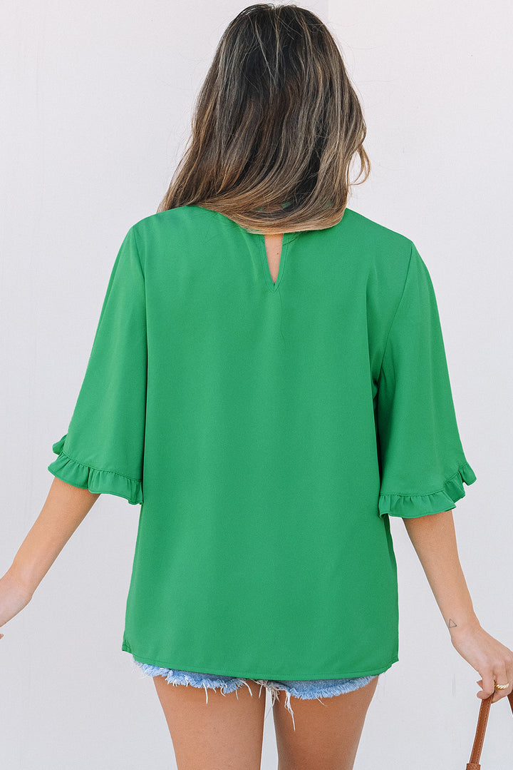 Back view of Green Frilly Round Neck Wide Half Sleeve Blouse worn with shorts, showcasing relaxed summer fashion.