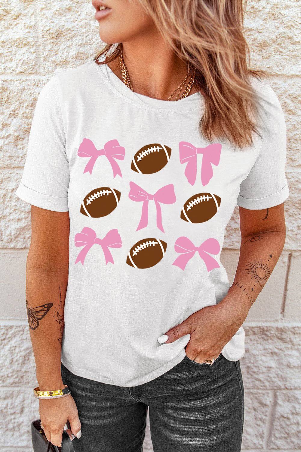 a woman wearing a white shirt with pink bows and footballs on it