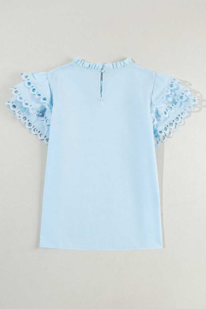 a baby blue top with a frilled collar
