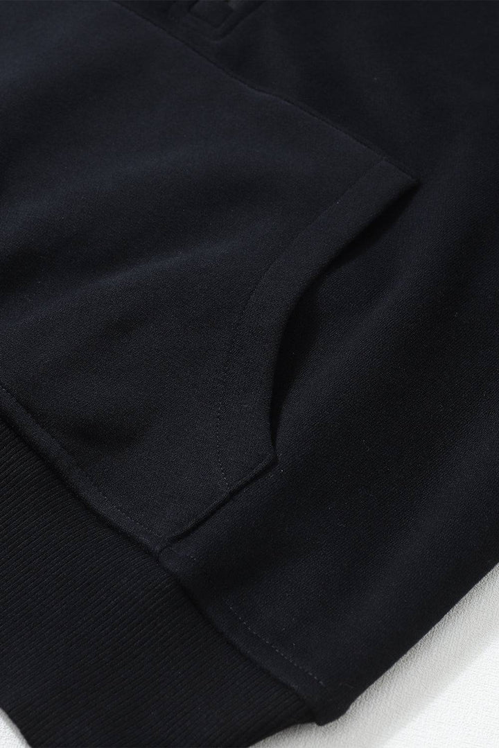 a close up of a black shirt on a white surface