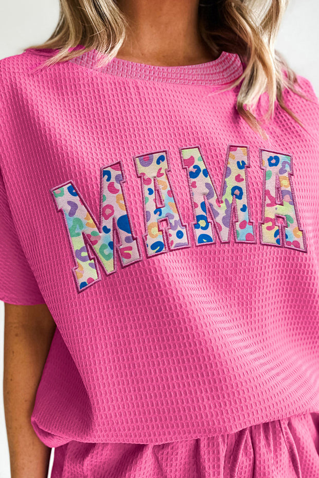 a woman wearing a pink t - shirt with the word mmm on it