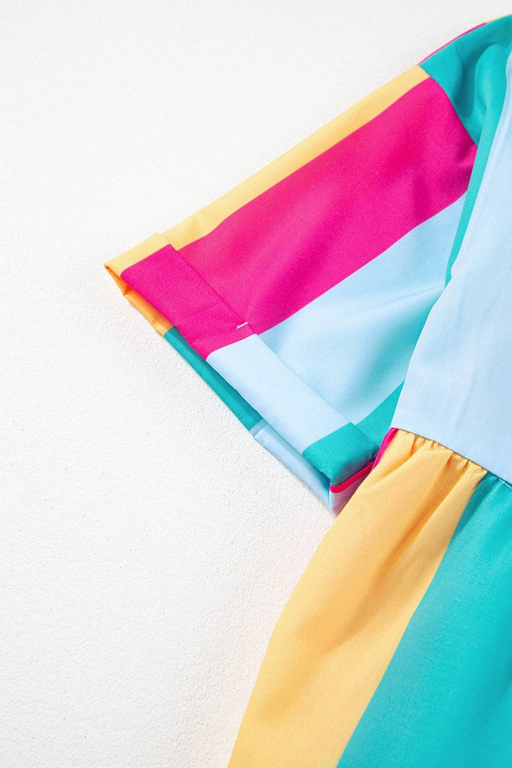 a rainbow colored dress is hanging on a wall