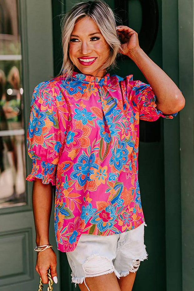 a woman wearing a colorful shirt and white shorts
