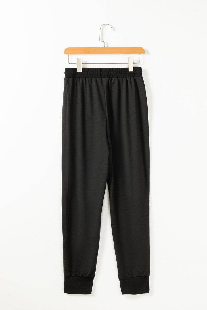 a pair of black pants hanging on a hanger