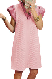 a woman in a pink dress talking on a cell phone