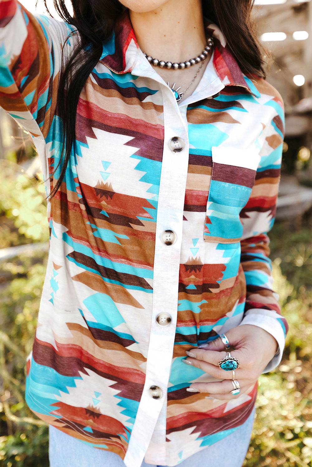 a woman wearing a hat and a colorful shirt