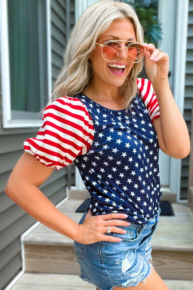 a woman wearing a patriotic top and denim shorts