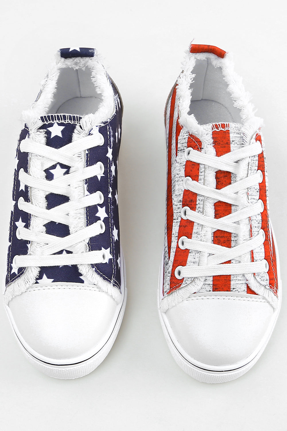 a pair of white and blue sneakers with red, white, and blue laces