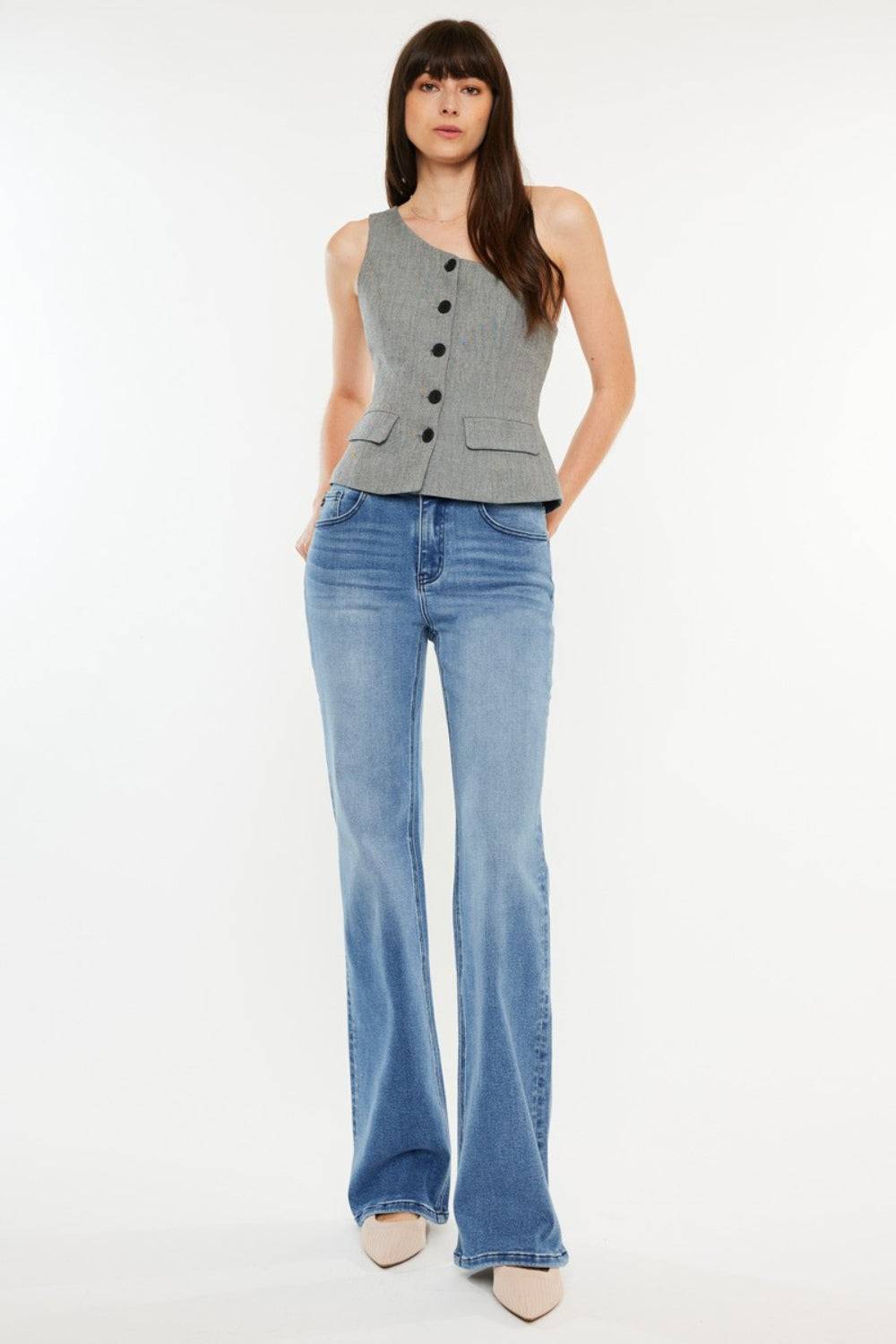 a woman wearing a gray vest and jeans