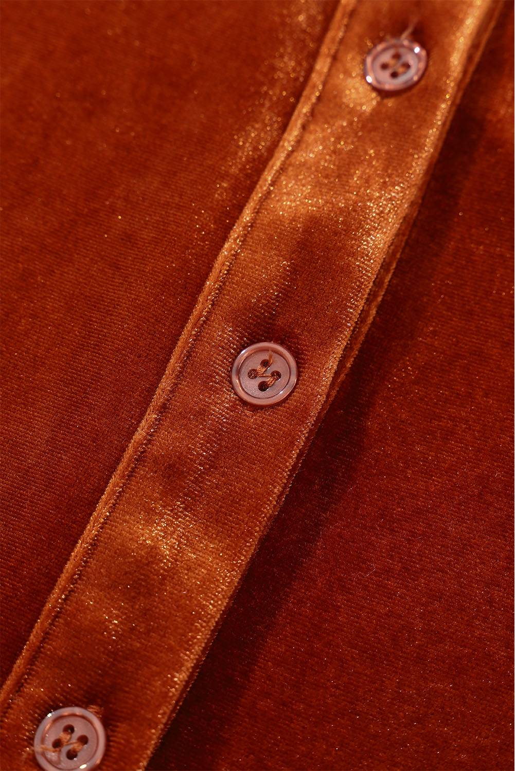 a close up of a button on a brown shirt