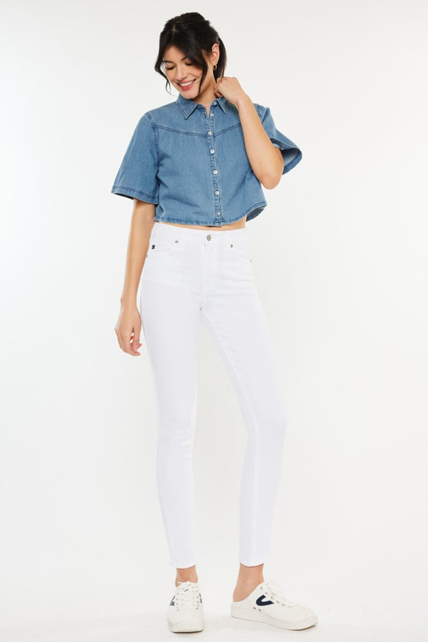 a woman wearing white jeans and a denim shirt