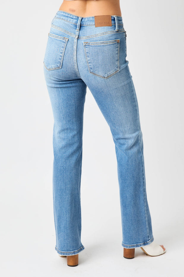 a woman in high rise jeans with her back to the camera