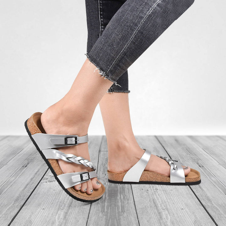 a woman's feet wearing sandals and jeans