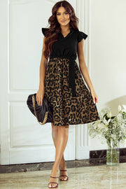 a woman in a leopard print dress holding a purse