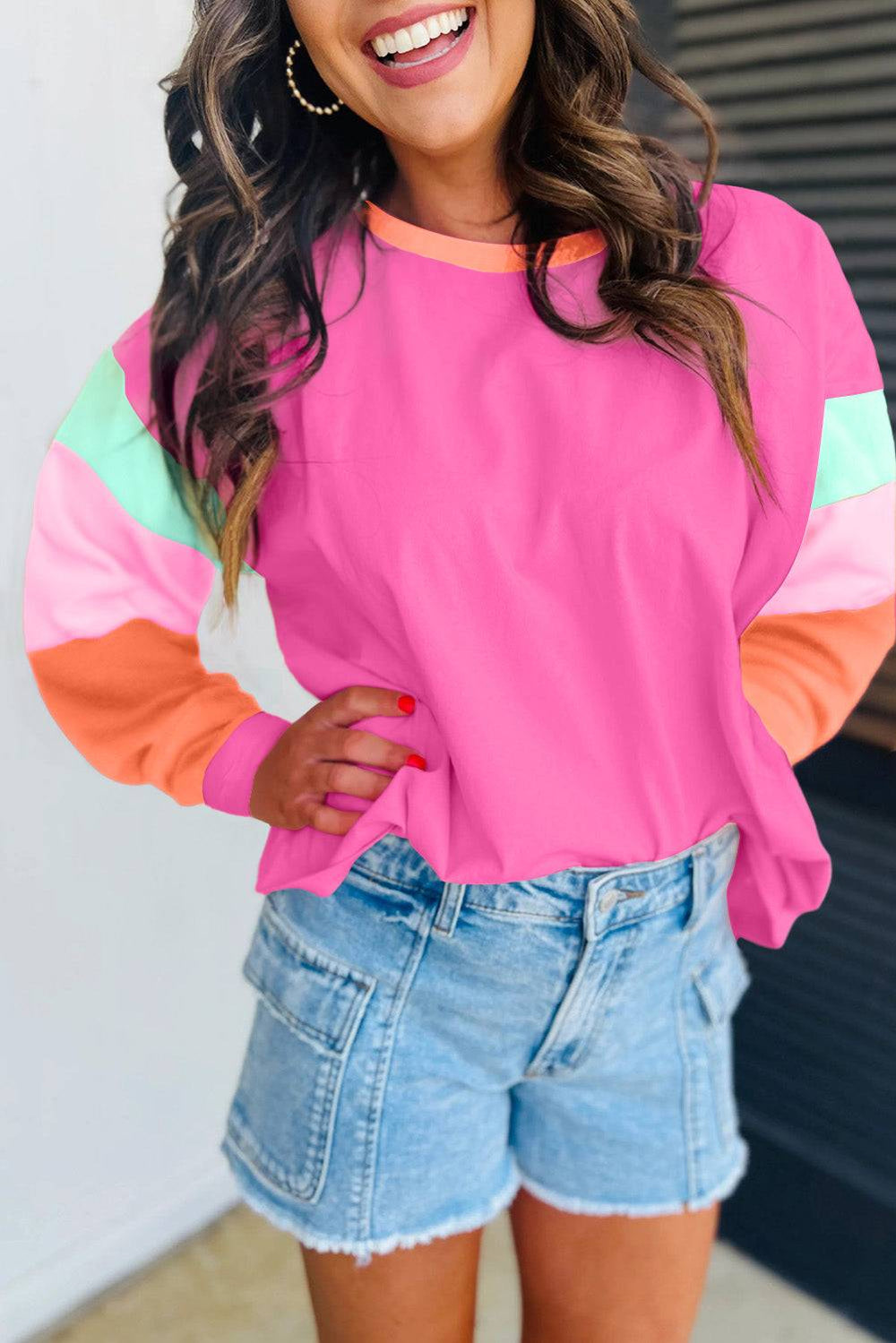 a woman wearing a pink top and denim shorts