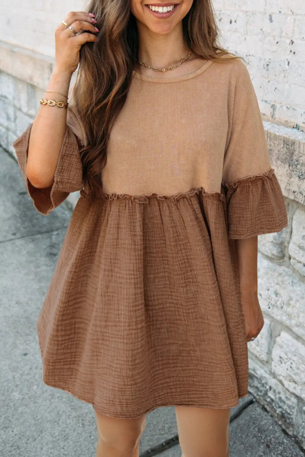 a woman wearing a brown dress and smiling