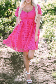 a woman in a pink dress walking down a path