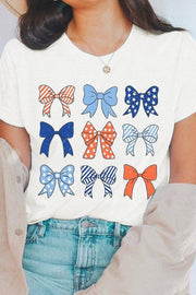 a woman wearing a white shirt with bows on it