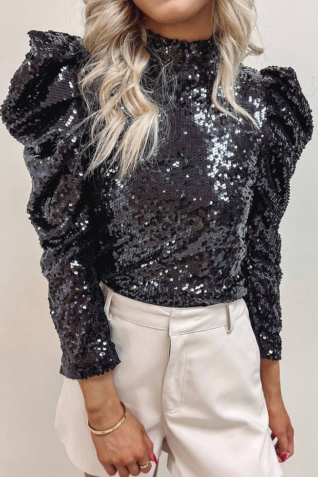 a woman with blonde hair wearing a black sequin top