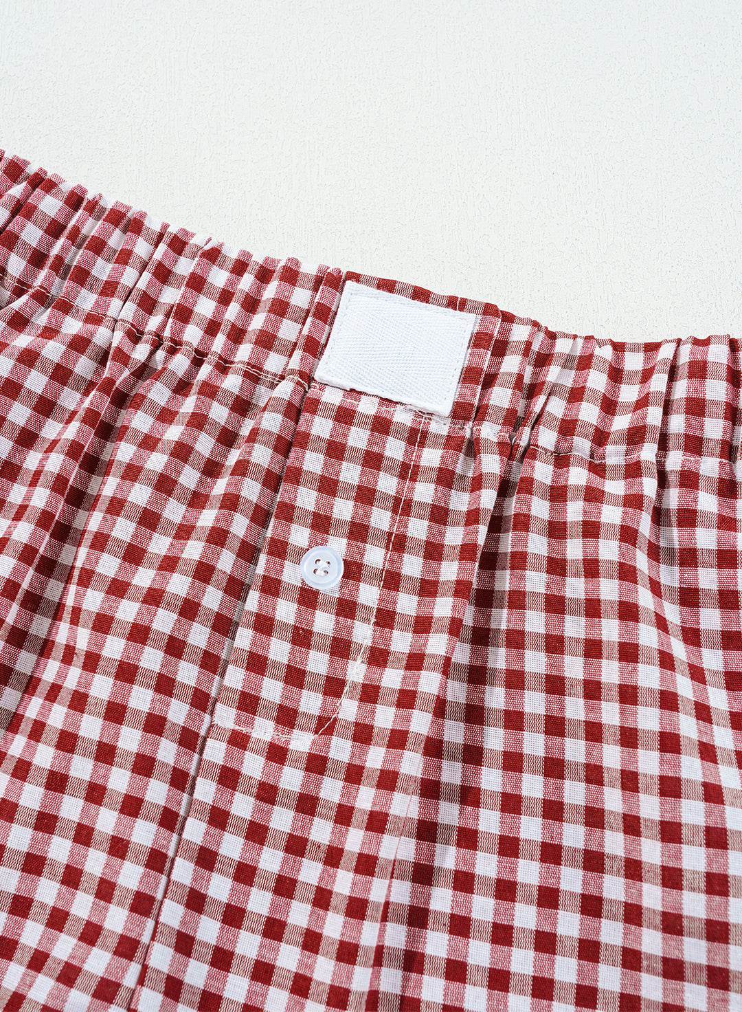 Detailed view of waistband and button closure on Red Plaid Gingham Printed High Waist Shorts. Shop stylish plaid summer shorts at Faith & Co. Boutique.