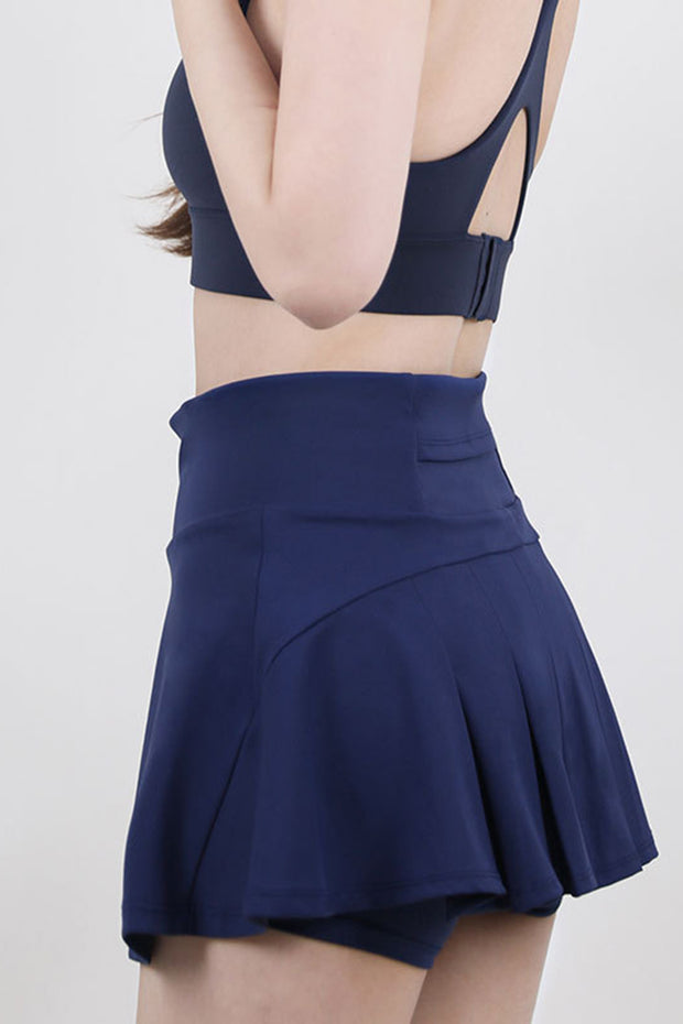 a woman wearing a blue skirt and a black top