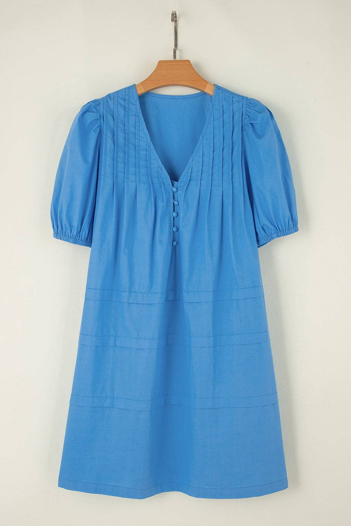 a blue blouse hanging on a wooden hanger