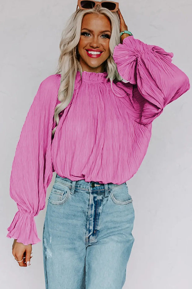 a woman wearing a pink top and jeans