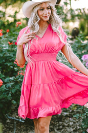a woman wearing a pink dress and a cowboy hat