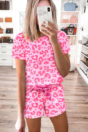 a woman taking a selfie in a pink leopard print pajamas
