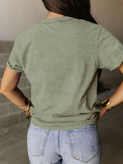 a woman in a green shirt is standing with her back to the camera
