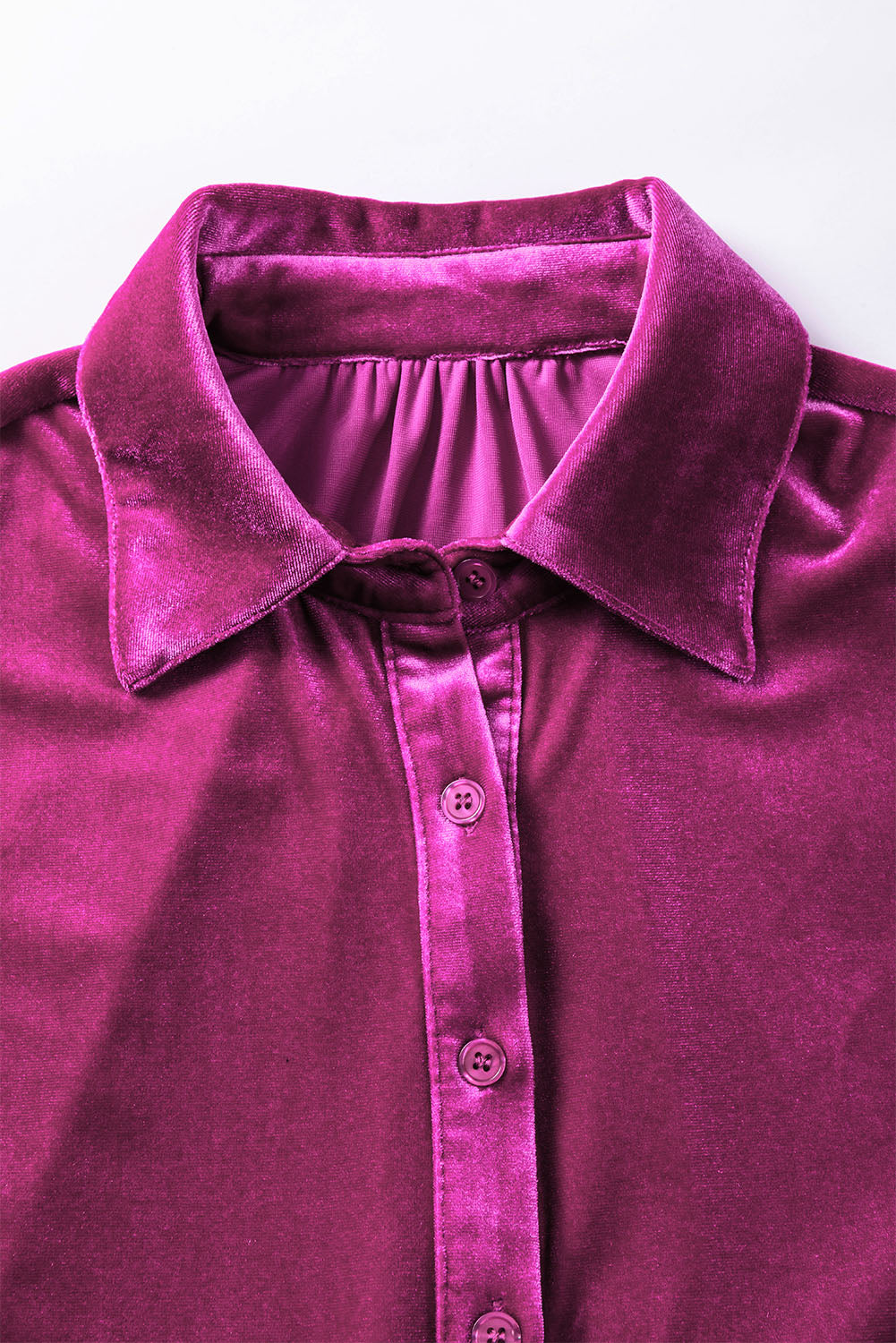 a close up of a purple shirt on a white surface