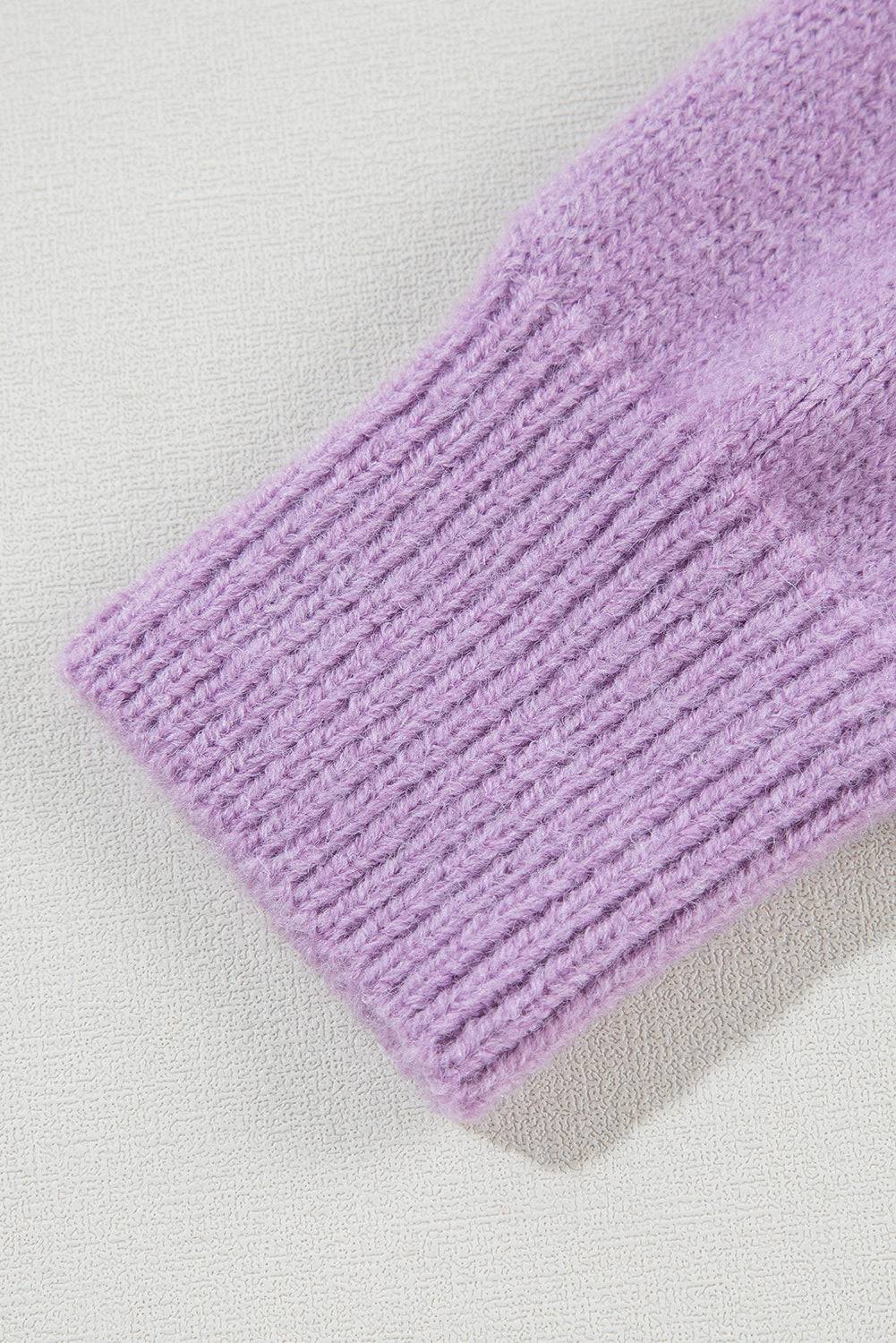 a close up of a purple sweater on a white surface