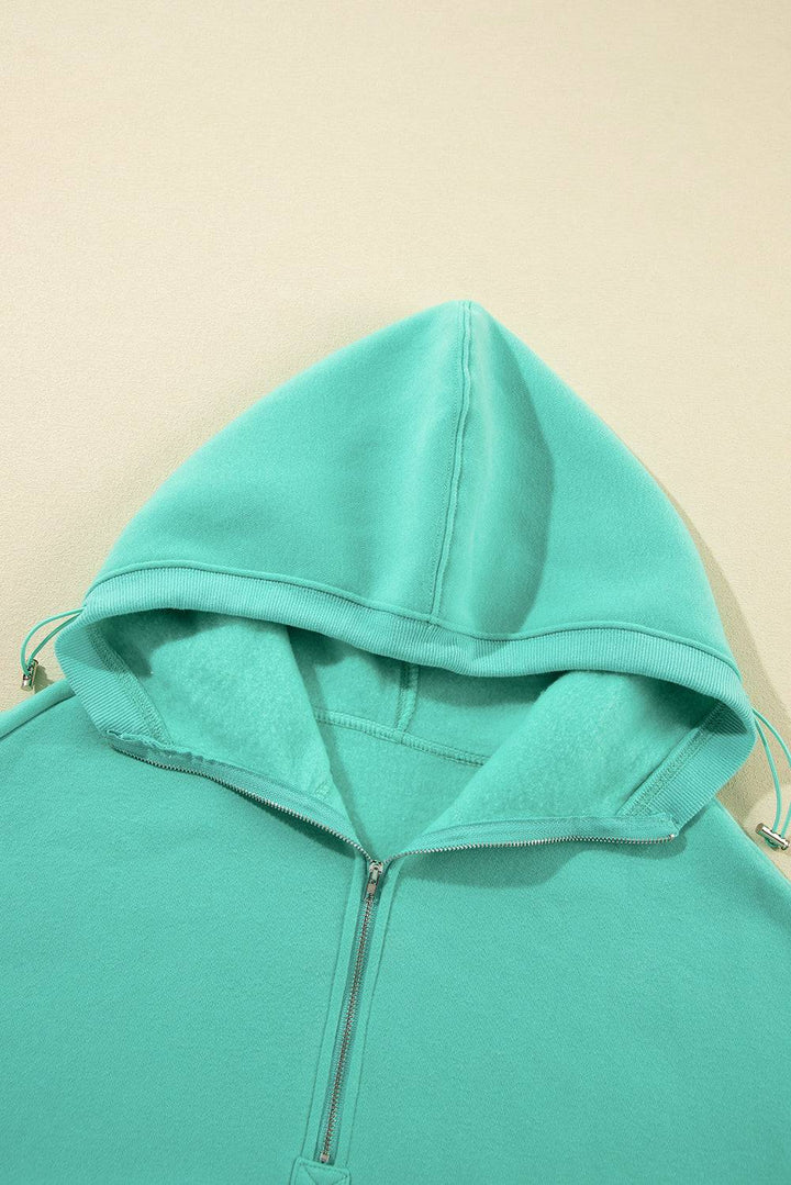 a close up of a person wearing a green hoodie