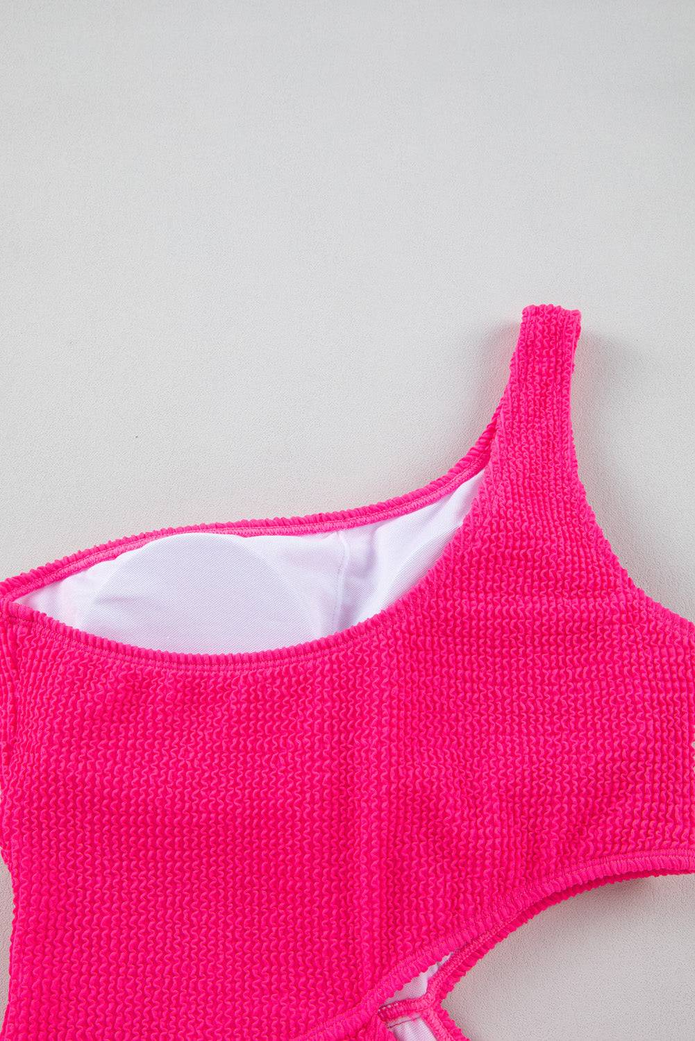 a pink knitted tank top laying on top of a table