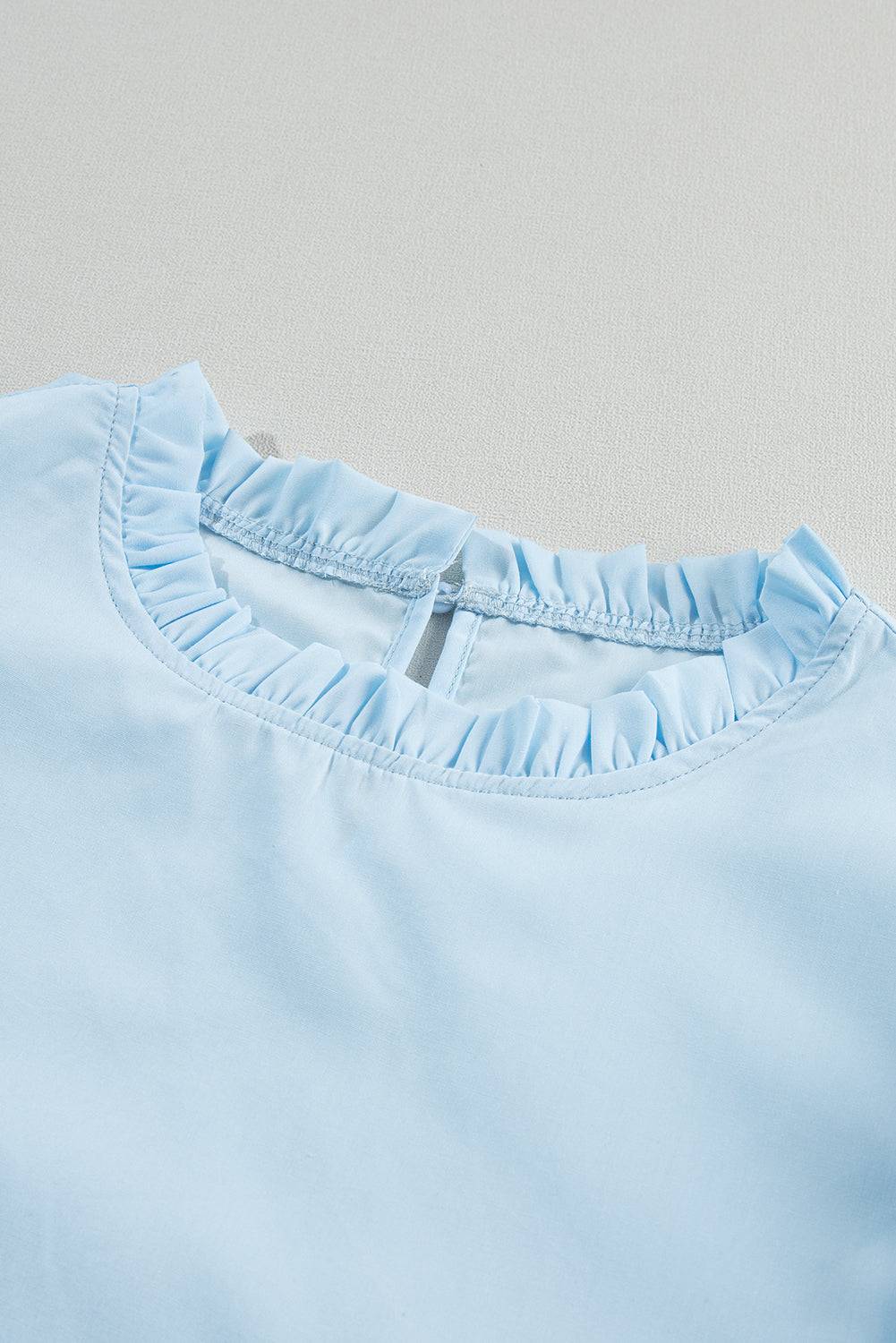 a close up of a blue shirt on a white surface