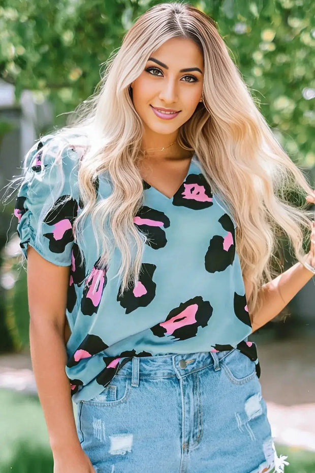 a woman with blonde hair wearing a blue top and jean shorts