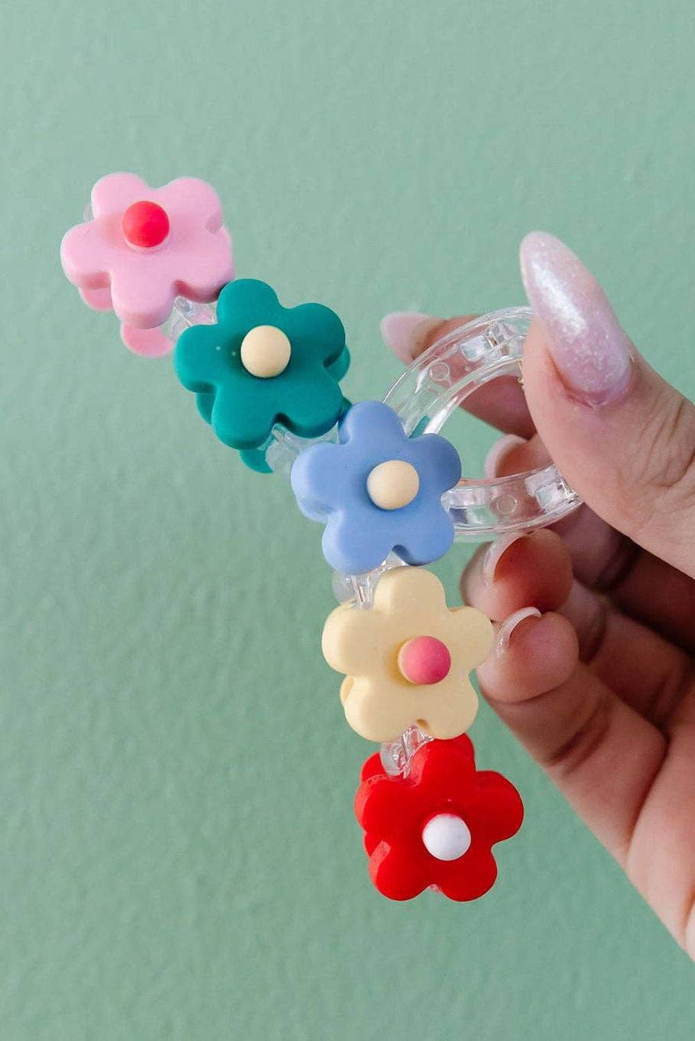 a hand holding a bunch of small plastic flowers