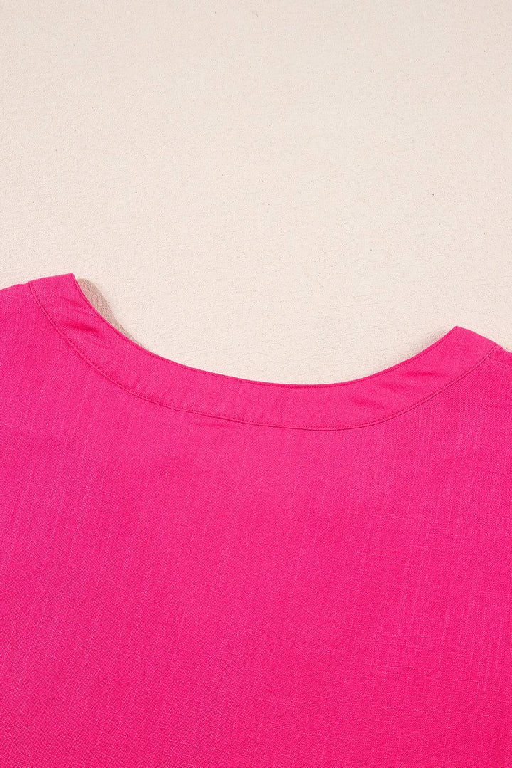 a close up of a pink shirt on a white surface