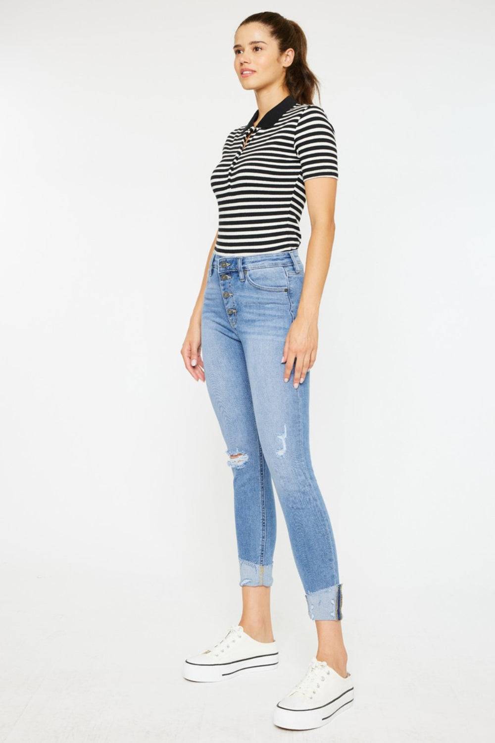 a woman in a striped shirt and ripped jeans