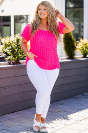 a woman wearing white pants and a pink top