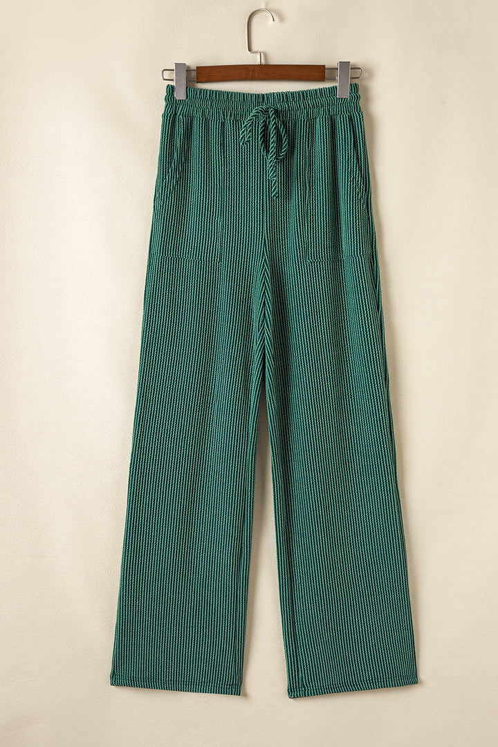 Front view of green Evergreen JOLLY Corded Pants with drawstring and pockets. Wide-leg silhouette perfect for lounging from Faith & Co. Boutique.