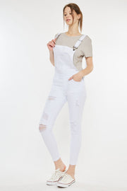 a woman in white overalls posing for a picture