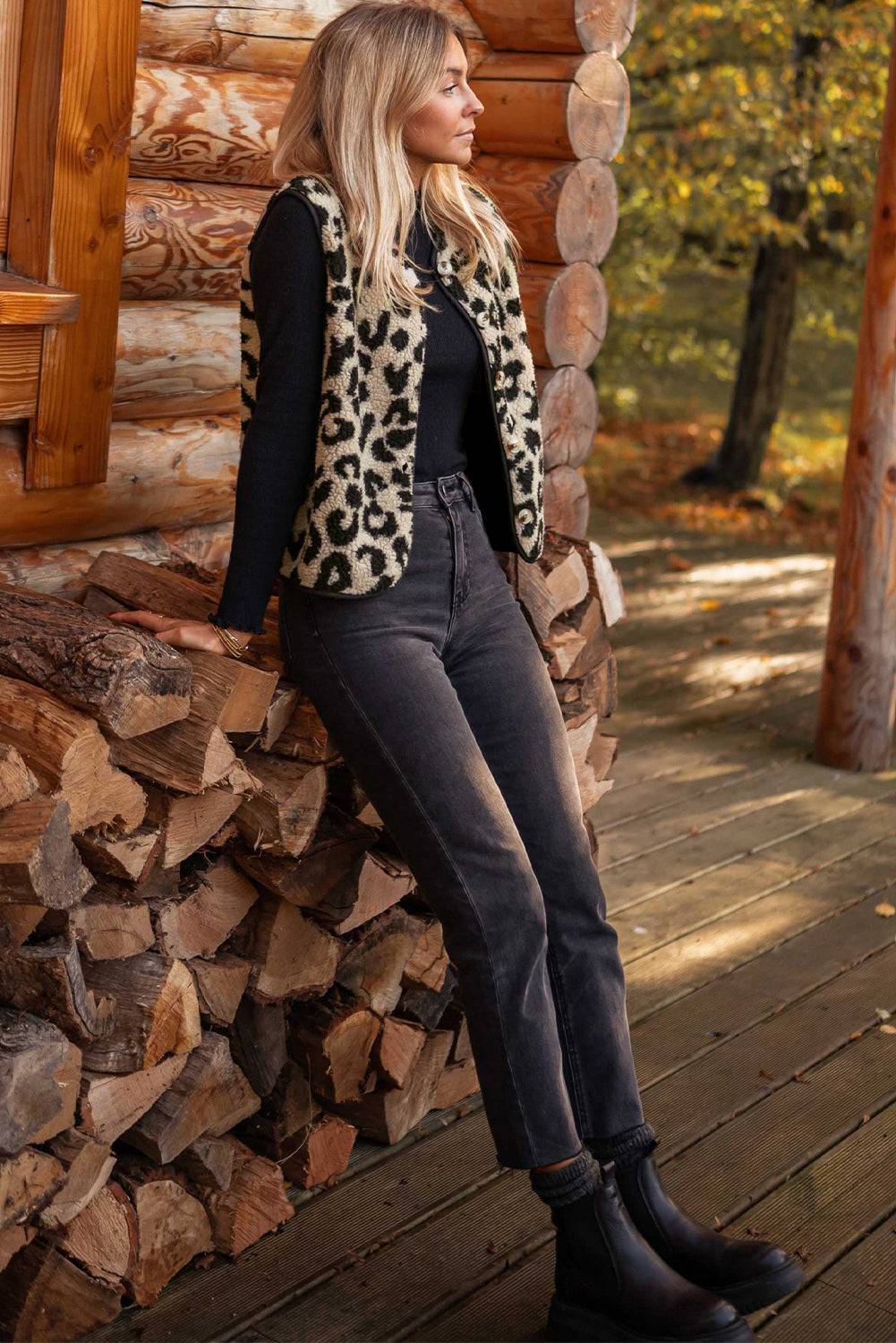 a woman leaning against a pile of logs