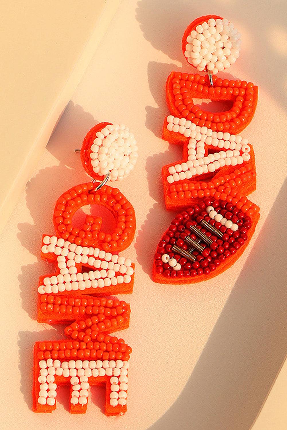 a pair of beaded earrings sitting on top of a table